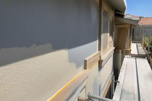 Partial paint application and masking tape on a multi-story apartment building exterior in Phoenix, AZ.
