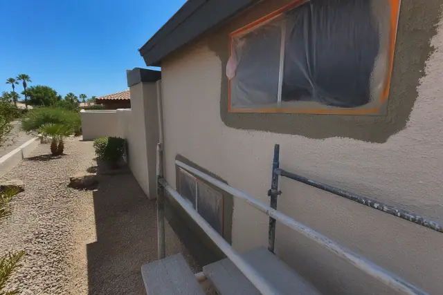 Stucco wall surfaces being prepped for repair with masking tape on a jobsite in Phoenix, AZ.