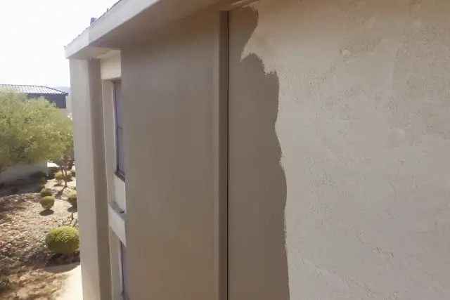 Fresh earth-tone paint applied to a stucco apartment building in Phoenix, AZ with desert landscaping visible below.