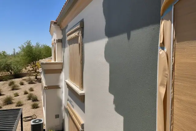 Partial exterior painting progress on a multi-story building facade in Phoenix, AZ, with masking tape and base coat visible.