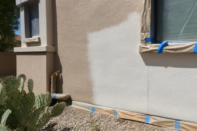 Freshly painted stucco wall with masking tape near a window and desert landscaping in Scottsdale, AZ.