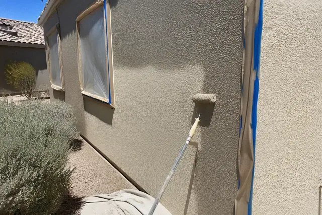 A contractor's progress shot of a stucco wall being painted near a window at a jobsite in Surprise, AZ.