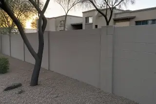 Finished masonry boundary wall with uniform coating and desert landscaping in a Phoenix, AZ residential community.