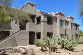 Finished exterior building facade with uniform paint, prickly pear cacti, and sharp desert shadows in Phoenix, AZ.