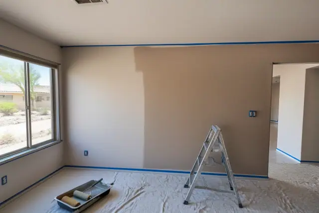 Interior painting in progress with taped trim and paint rollers in a residential home in Surprise, AZ.