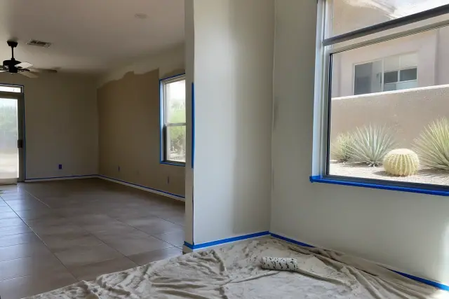 Freshly painted residential living room walls with painter's tape and tools in Peoria, AZ.