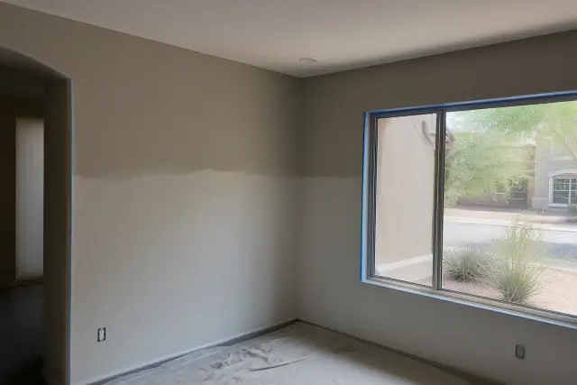Freshly painted living room walls with taped trim at a residential job site in Chandler, AZ.