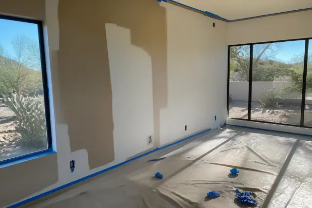 Interior wall painting in progress with taped trim and wet roller marks in a Scottsdale, AZ home.