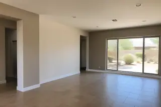 Wide view of a freshly painted living room interior in a Phoenix, AZ home with desert landscaping visible outside.