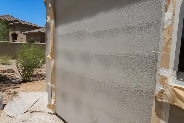 Thick, uneven paint lap marks on a stucco wall at a worksite in Phoenix, AZ.