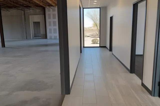 Contrast between an unfinished warehouse section and finished office flooring in a Phoenix, AZ professional building.