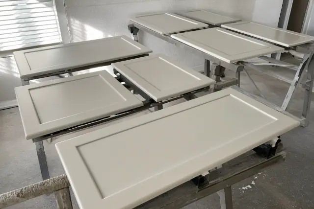 Dismantled cabinet doors with smooth enamel finish drying in a Phoenix, AZ workshop.