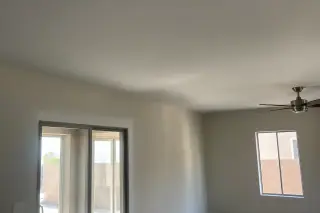 Smooth drywall ceiling and wall corner after popcorn texture removal in a Phoenix, AZ home.