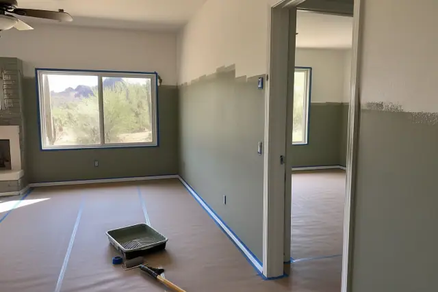 Residential interior painting in progress with taped trim and fresh wall color in a living room in Phoenix, AZ.