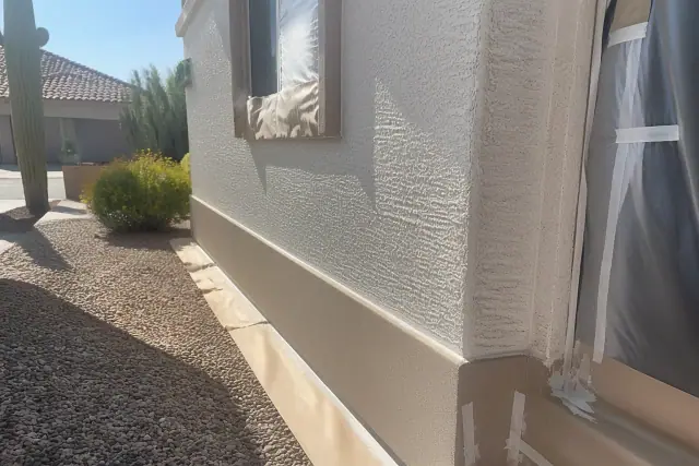Stucco wall prepared for exterior painting with protective masking at a residential home in Phoenix, AZ.