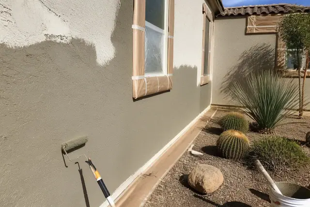 Contractor applying wet elastomeric stucco to a residential exterior wall in Scottsdale, AZ.