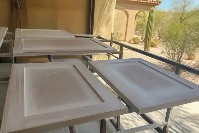 Cabinet doors with primer on drying racks at a workshop in Phoenix, AZ.
