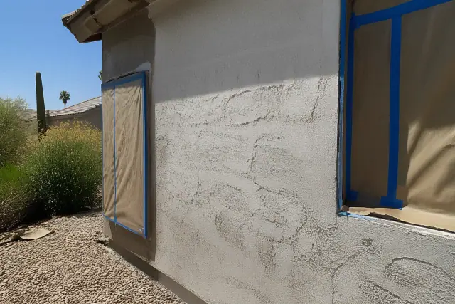 Weathered stucco exterior wall prepared for repainting at a residential job site in Phoenix, AZ.