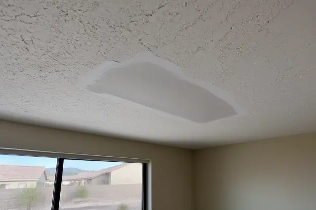 Sanded drywall ceiling patch with thick texture ready for painting in a Phoenix, AZ home.