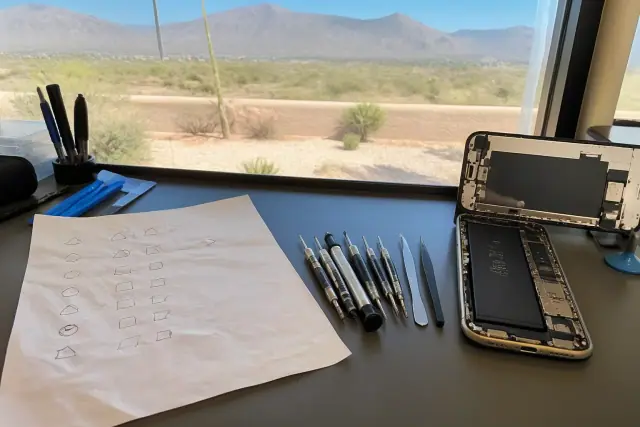 Pre-repair privacy checklist and smartphone tools on a workstation in Phoenix, AZ.