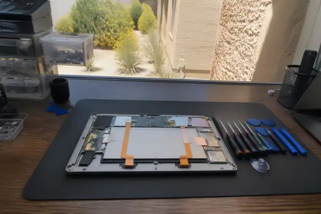 Android tablet repair workstation with professional tools and exposed internal components in Mesa, AZ.