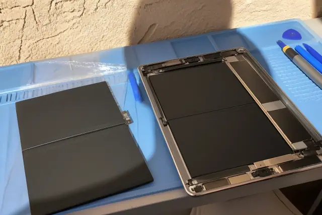 Replacement battery and repair tools for an iPad on an anti-static mat in Phoenix, AZ.