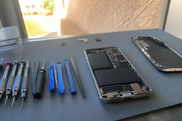 Smartphone being repaired at a workbench with professional tools in Mesa, AZ.