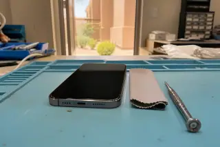 Reassembled smartphone on a static mat with a microfiber cloth at a Phoenix, AZ workshop.