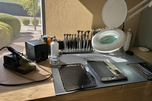 An organized repair workbench with tools and an opened device in Phoenix, AZ.
