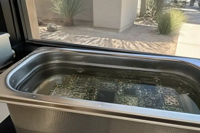 A circuit board with mineral deposits being cleaned in an ultrasonic bath at a workshop in Phoenix, AZ.