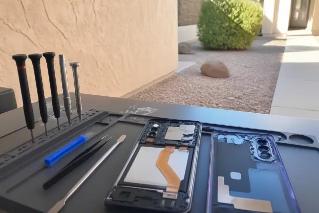 Opened Galaxy A series smartphone with repair tools on a workstation in Phoenix, AZ.