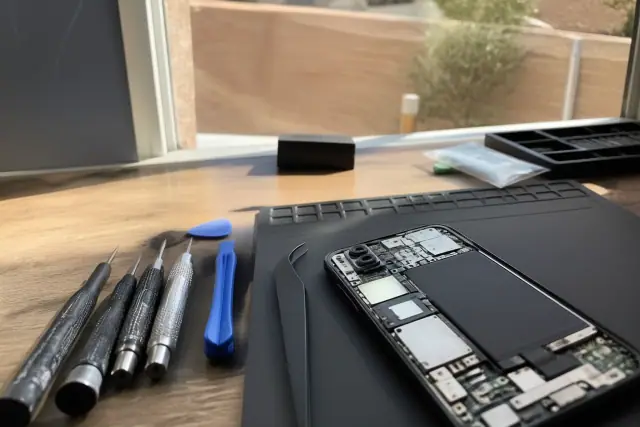 Open Google Pixel smartphone with internal components on a workbench in Phoenix, AZ.