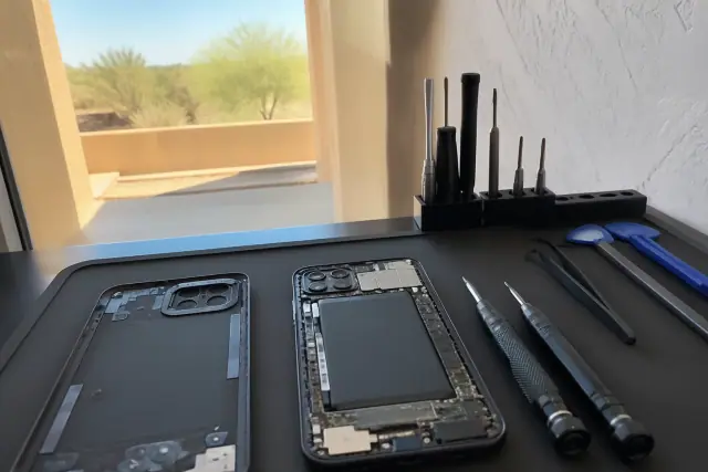 Opened Google Pixel with internal components and repair tools on a workstation in Glendale, AZ.