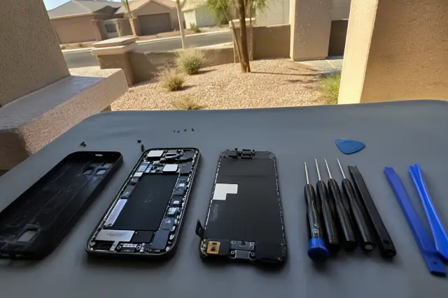 Opened smartphone with internal components on a repair workstation in Goodyear, AZ.