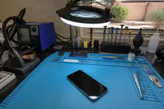 Assembled smartphone on a repair workbench with tools in a Phoenix, AZ workshop.