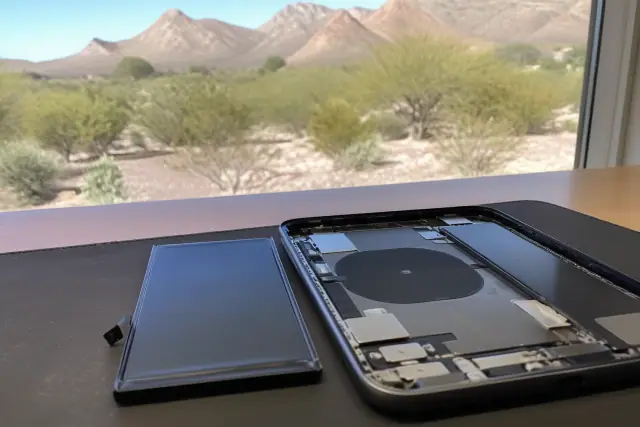 An open smartphone with a new replacement battery ready for installation in Paradise Valley, AZ.