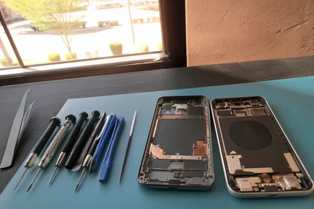 Smartphone repair workbench showing internal components and tools in Phoenix, AZ.