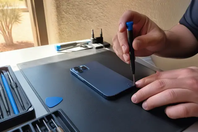 Smartphone rear glass and camera repair in progress at a workbench in Phoenix, AZ.