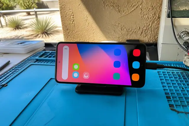 Smartphone screen being tested with diagnostic cables on a workbench in Chandler, AZ.