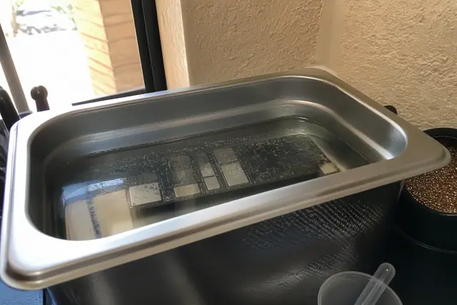 A circuit board being cleaned in an ultrasonic bath during a phone repair in Phoenix, AZ.