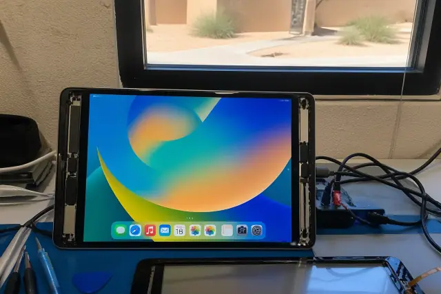 Technician testing a newly installed iPad screen on a diagnostic bench in Phoenix, AZ.