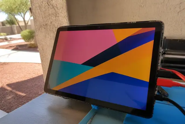 Tablet with a new touch screen display connected to diagnostic cables at a repair workstation in Phoenix, AZ.