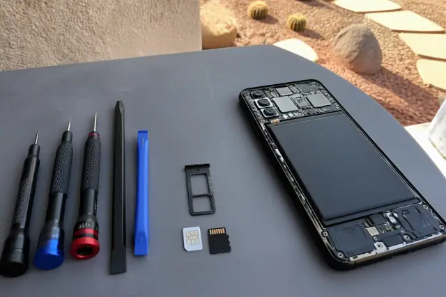 SIM tray with cards removed from an opened smartphone on a workbench in Phoenix, AZ.