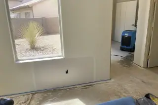Moisture-sealed drywall patch with a dehumidifier in a Phoenix, AZ home repair project.