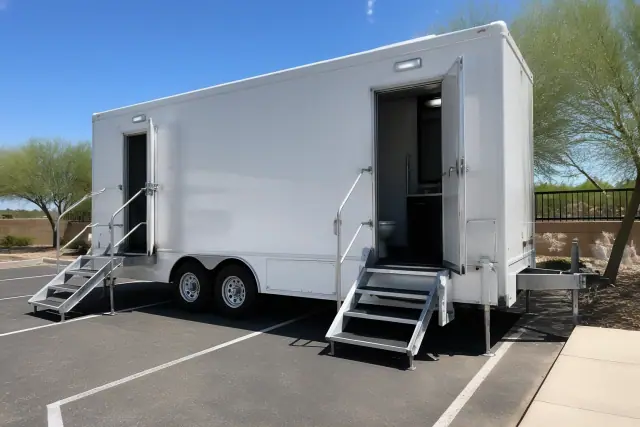 A luxury portable restroom trailer placed on an asphalt parking lot in Phoenix, AZ.
