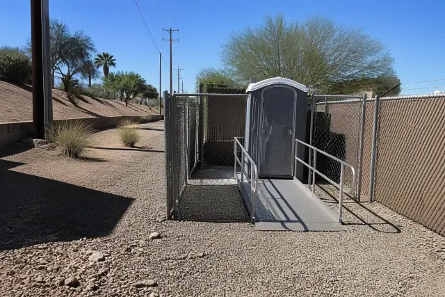 ADA-compliant portable restroom with a ramp on a gravel construction site in Phoenix, AZ.