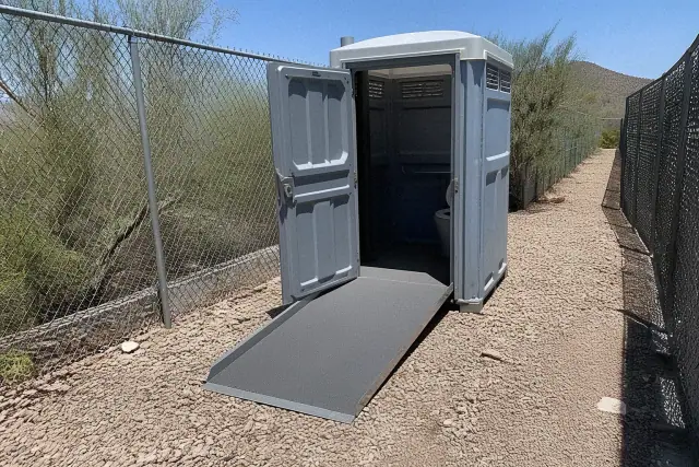 ADA-compliant portable toilet with ramp on a gravel jobsite in Goodyear, AZ.