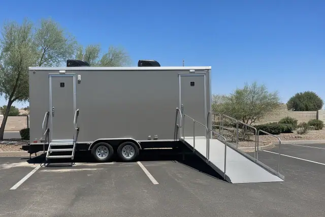 Climate-controlled ADA restroom trailer with ramp parked on an asphalt lot in Phoenix, AZ.