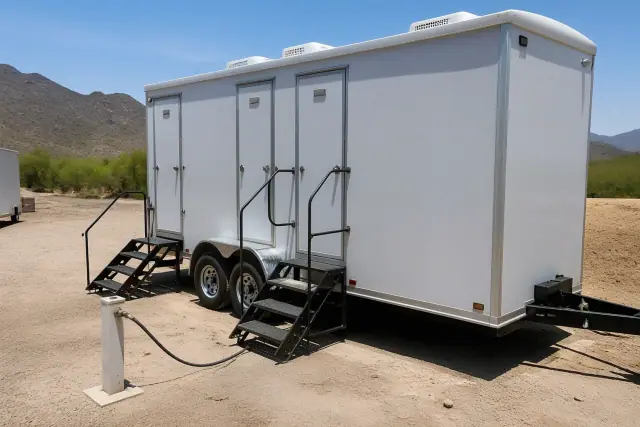 Climate-controlled shower trailer installed on a dirt lot with desert mountains in the background in Phoenix, AZ.
