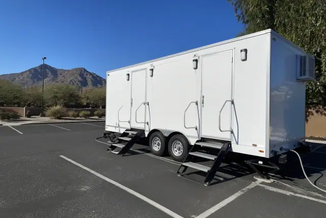 Luxury restroom and shower trailer installed in a paved parking lot with mountain views in Phoenix, AZ.
